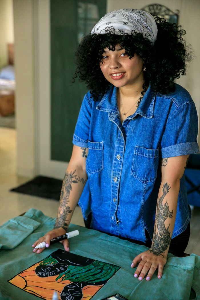 Artistic woman crafts a unique denim jacket with personalized designs in a cozy studio setting.
